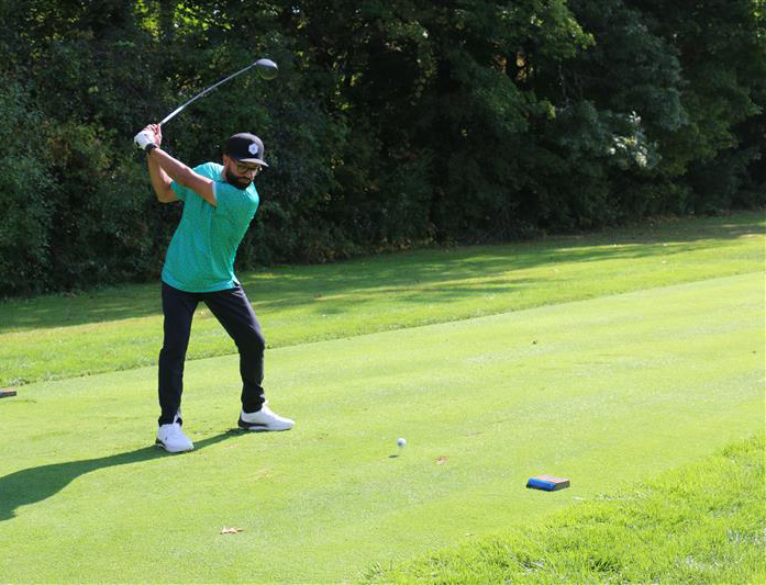 A golfer about to hit a drive from the starting tee