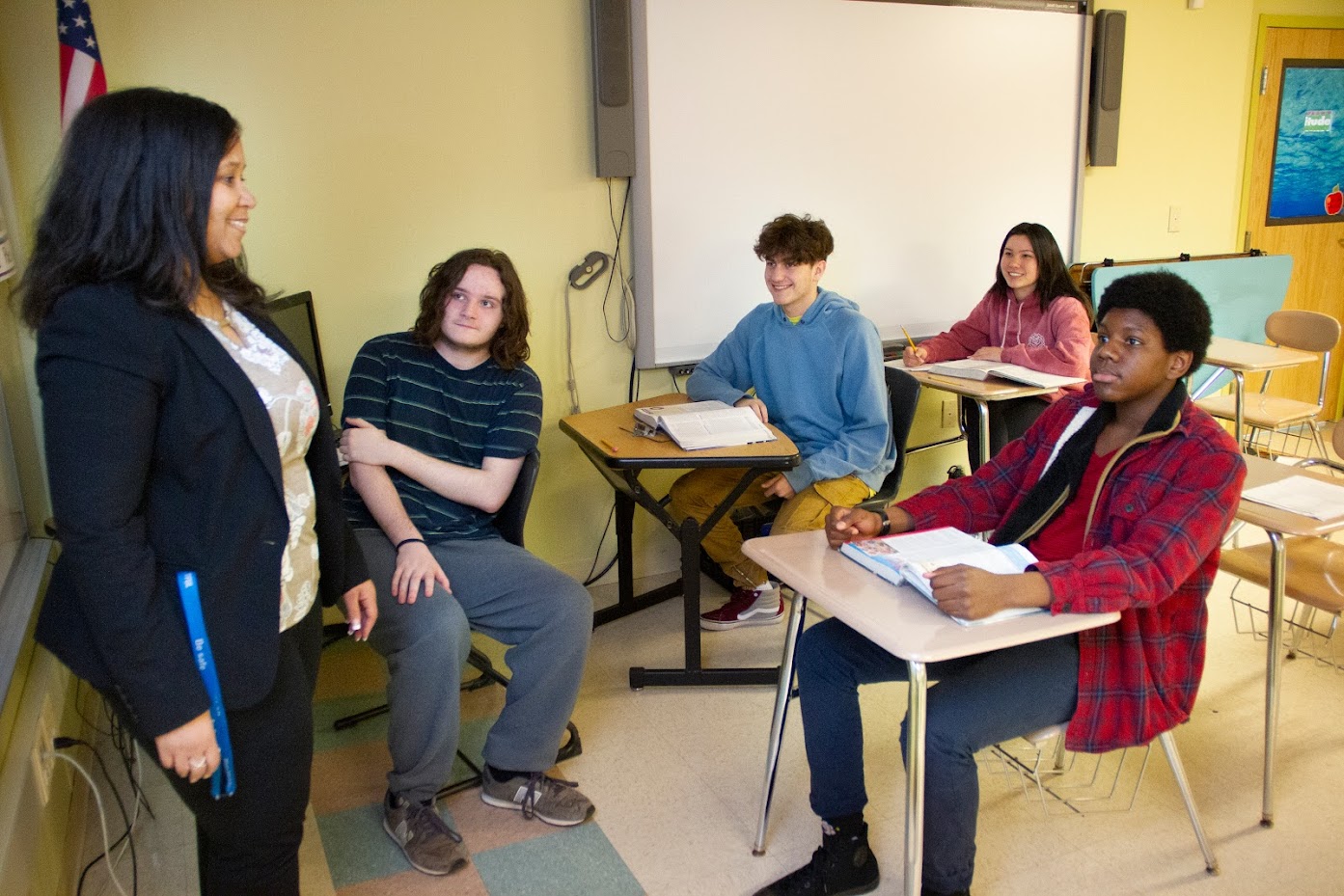 Students in a small classroom intimately listening to thier teacher