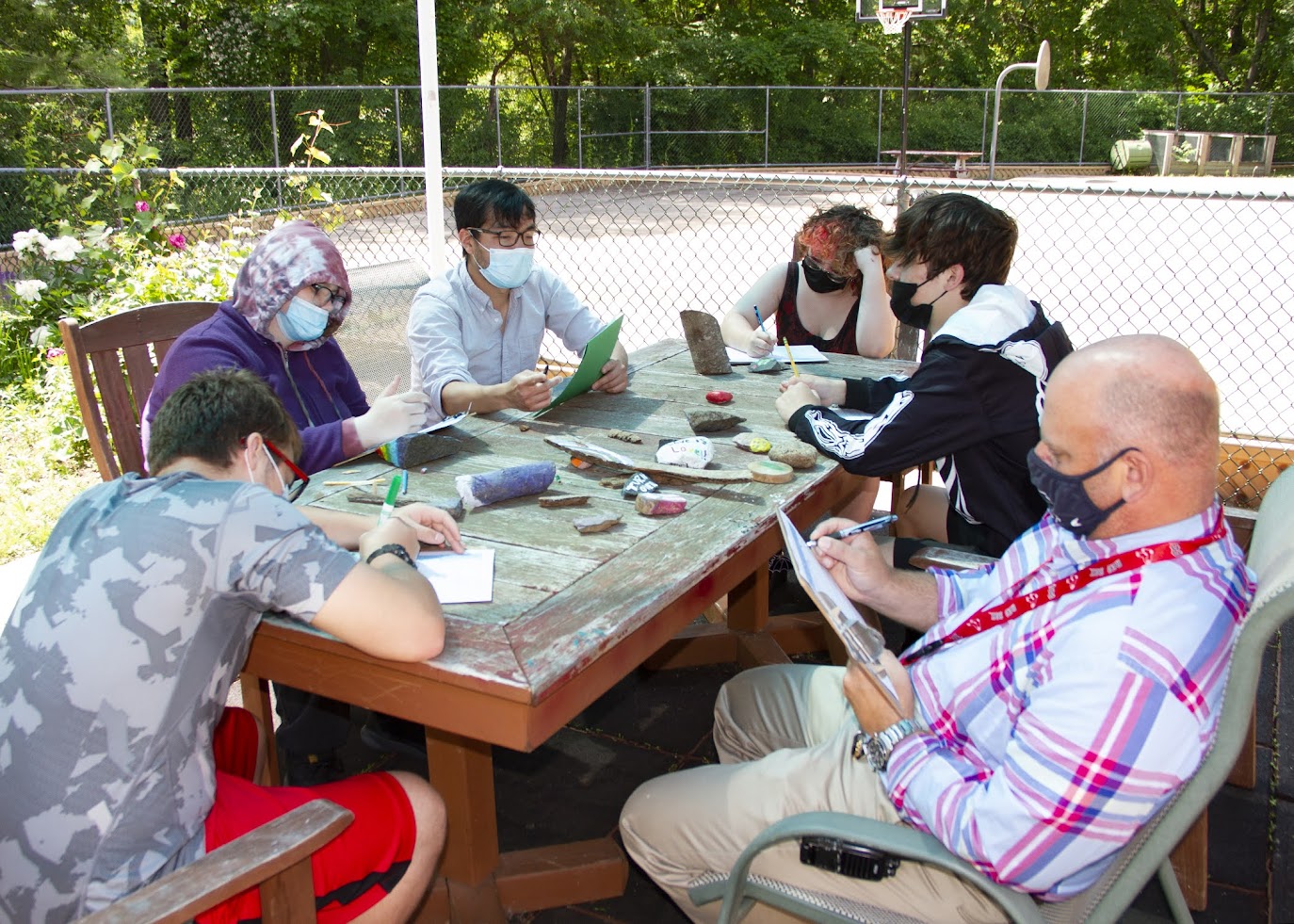 Students enjoying a lesson outside taking notes about nature