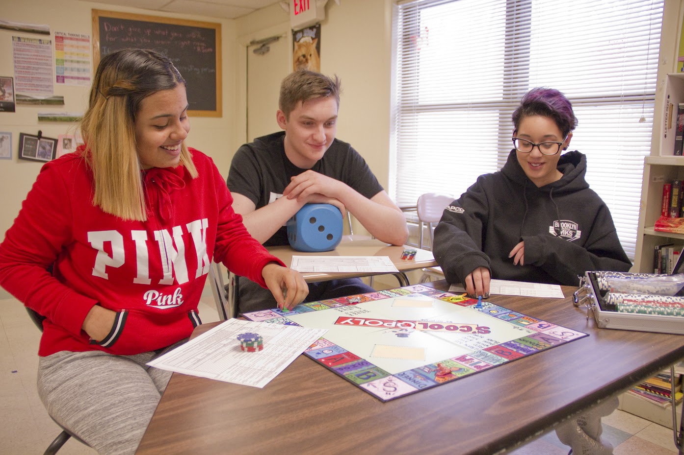 Students playing a custom Monopoly game called S'Coolopoly